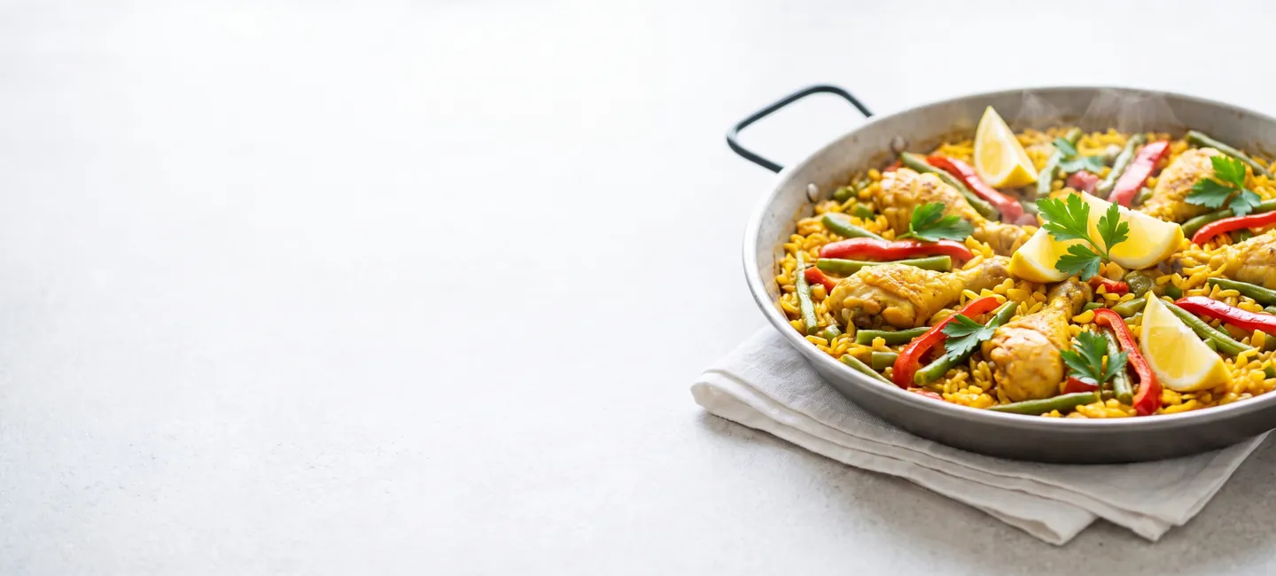 Paella de pollo y verduras con judías verdes, pimiento rojo y limón