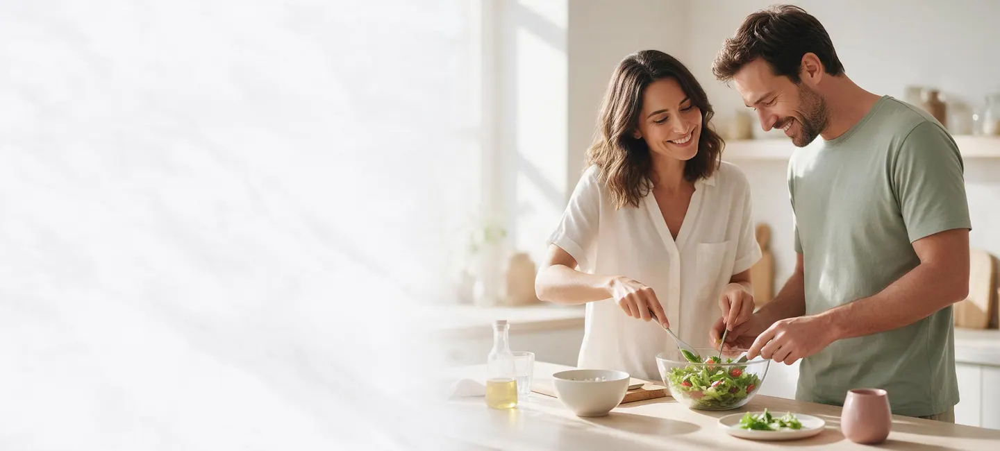 Pareja joven preparando juntos una ensalada en la cocina
