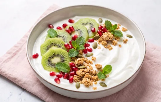 Bol de yogur griego con kiwi, granada, granola y pipas de calabaza